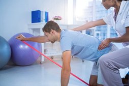 Patient doing a shoulder stretch exercise with band