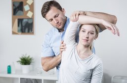 Physical Therapist stretching patients arm