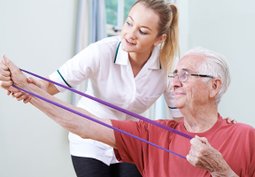 Physical Therapist assisting patient on band exercise