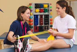 Physical Therapist showing patient how to stretch with band