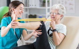 Patient stretching her ankle and leg with band