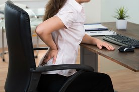 Woman at desk with low back pain