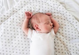 Infant laying in bed with torticollis