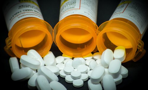 Three medicine bottles holding pills